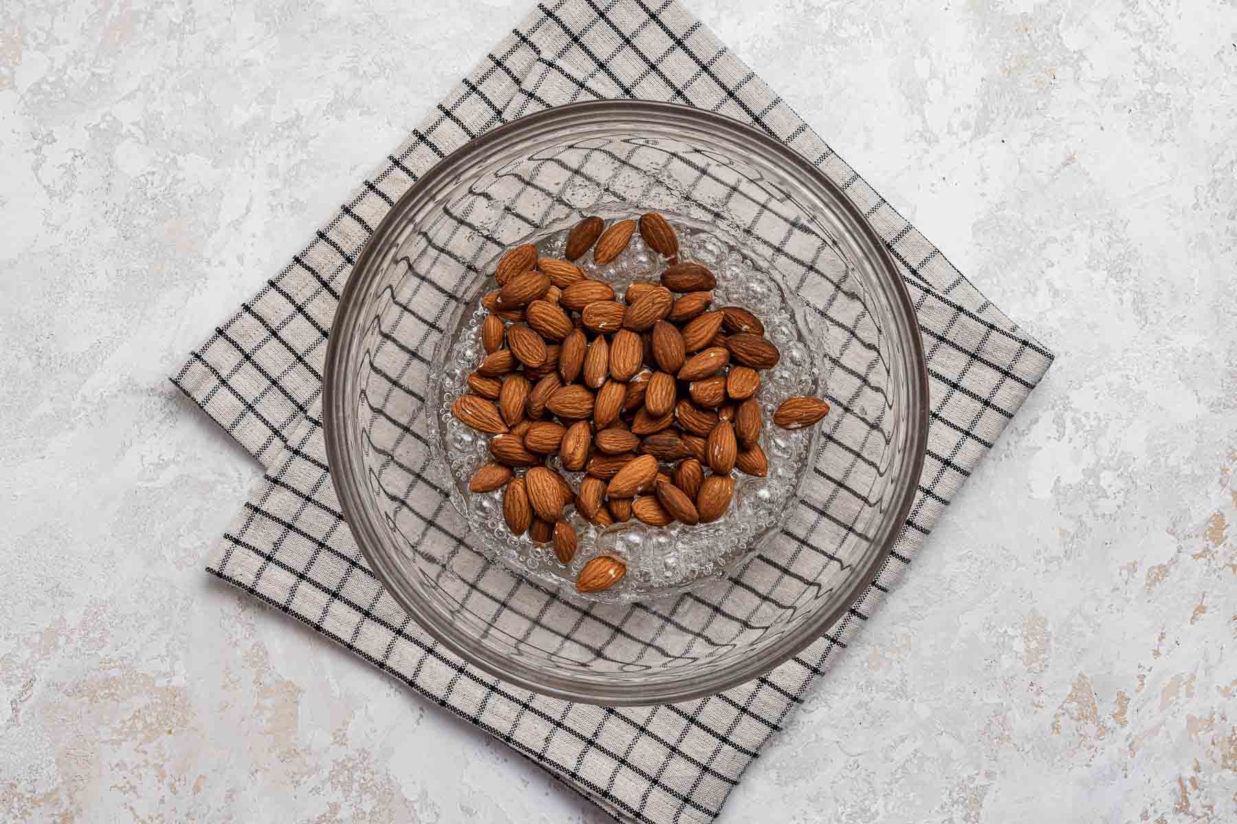 Whole almonds going into boiling sugar to make brittle.