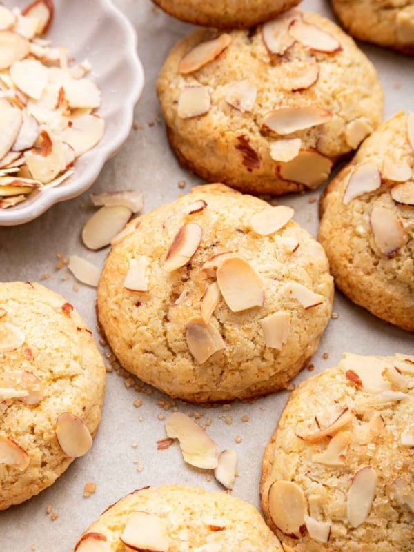 Macro shot of almond croissant cookies with sliced almonds on top.