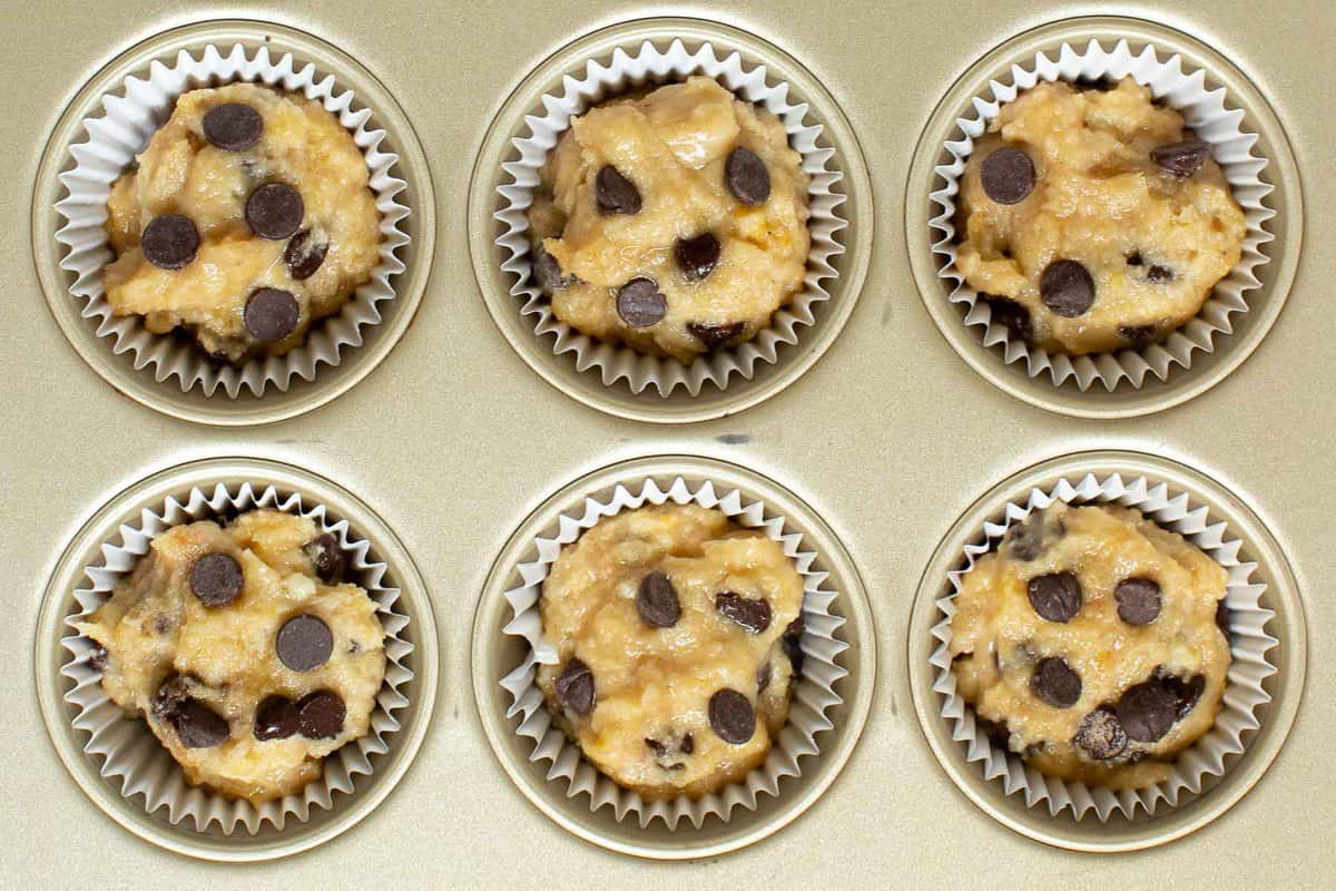 Raw banana chocolate chip muffins in muffin pan with liners.