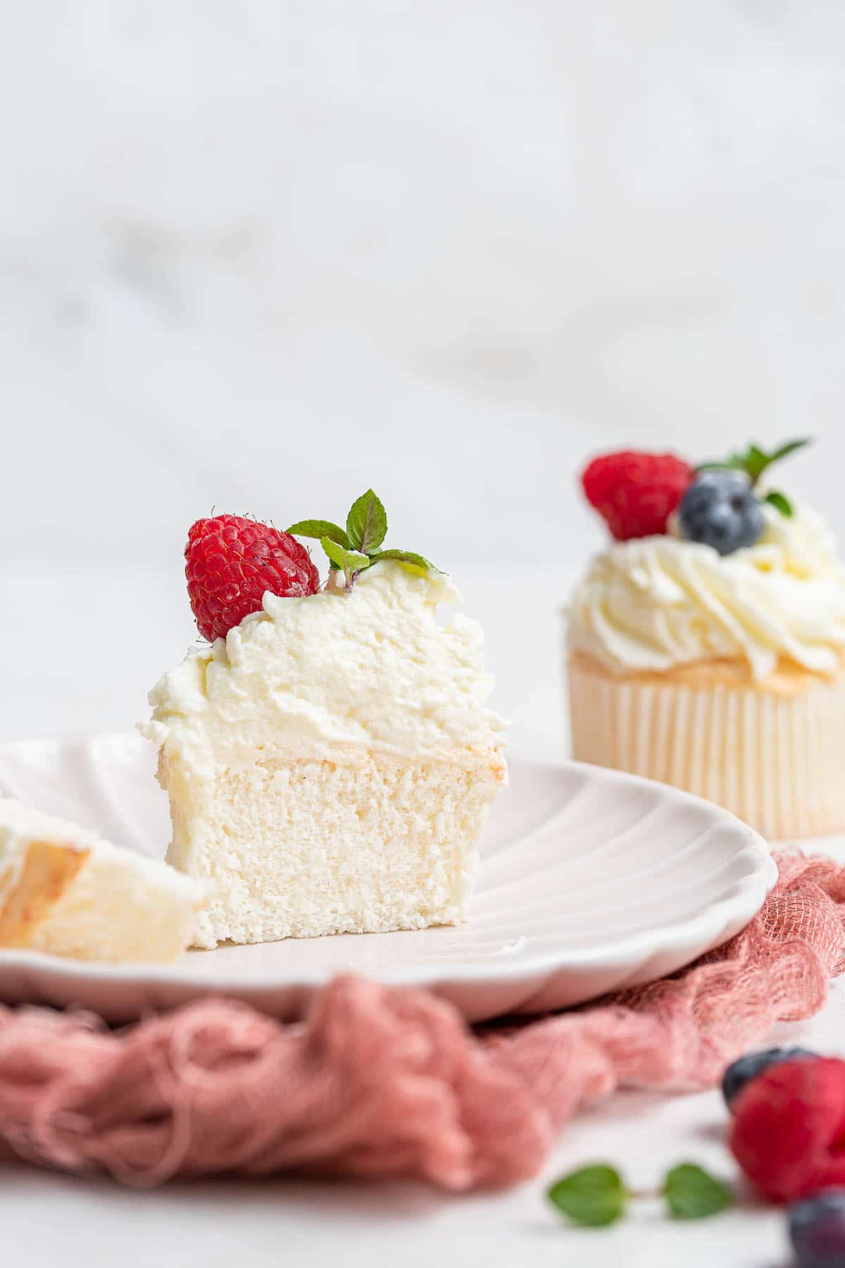 Angel food cake cupcake, sliced in half.