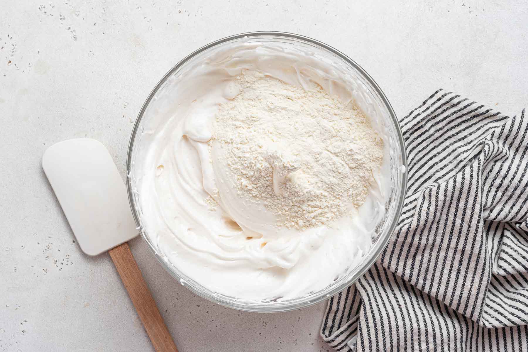 Dry ingredients over beaten egg whites in bowl.