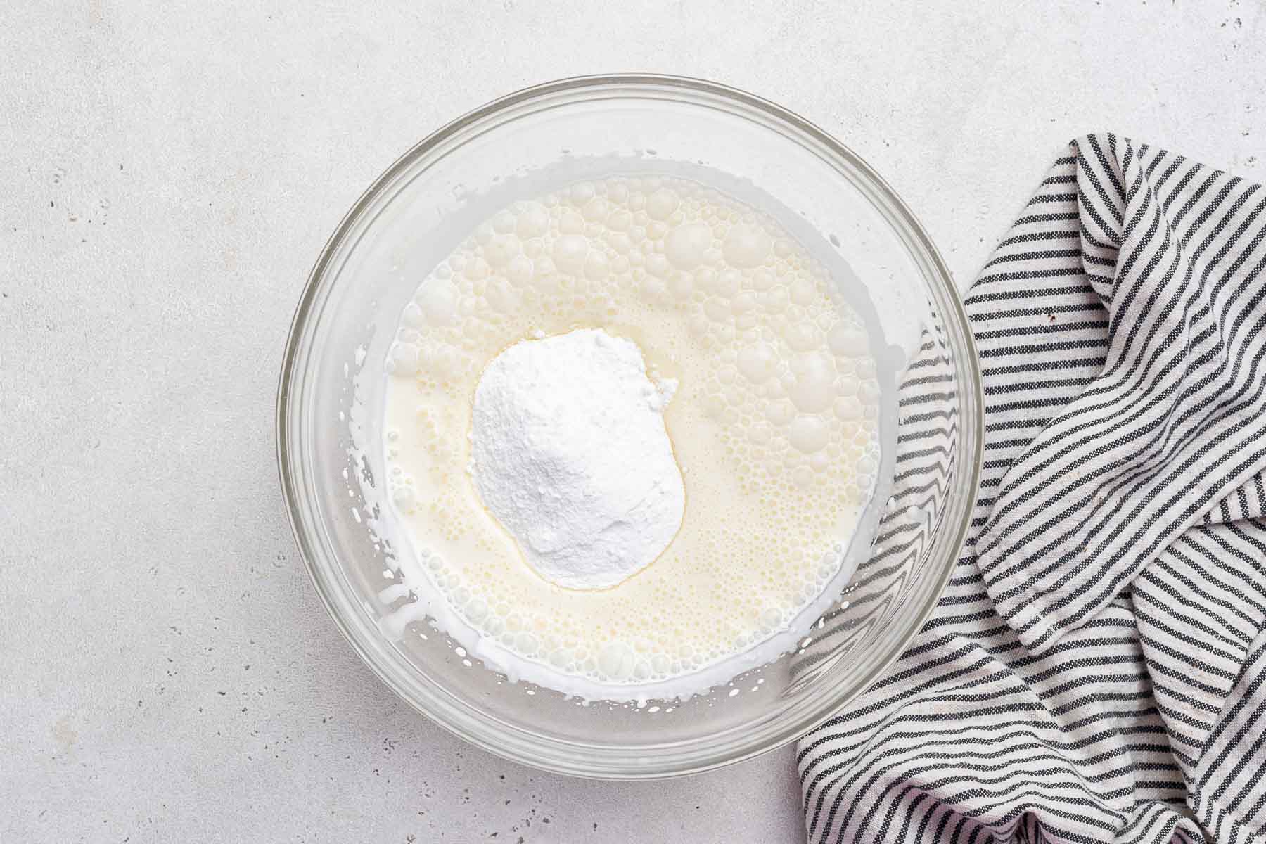 Whipped cream frosting ingredients in bowl.