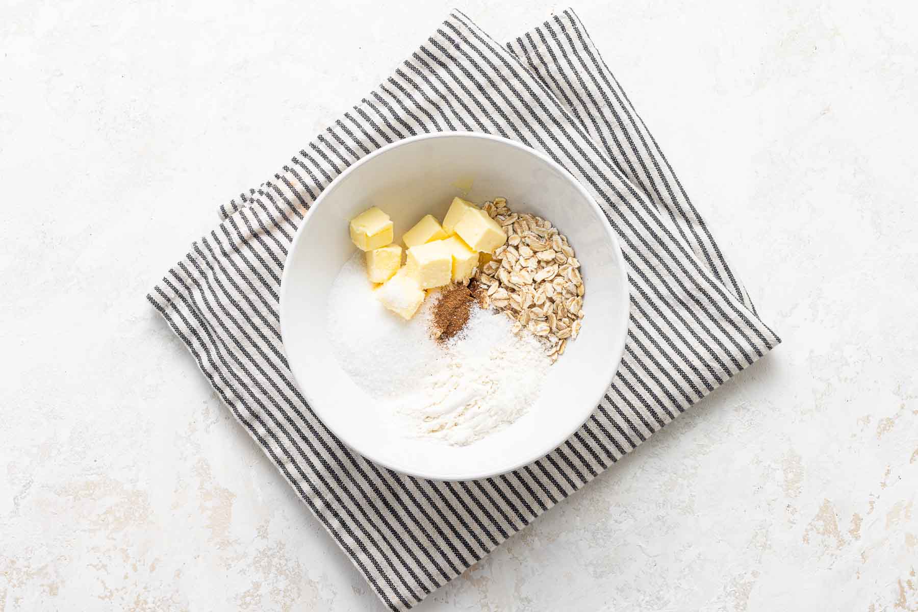 Ingredients for the topping for apple crisp with oats in bowl.
