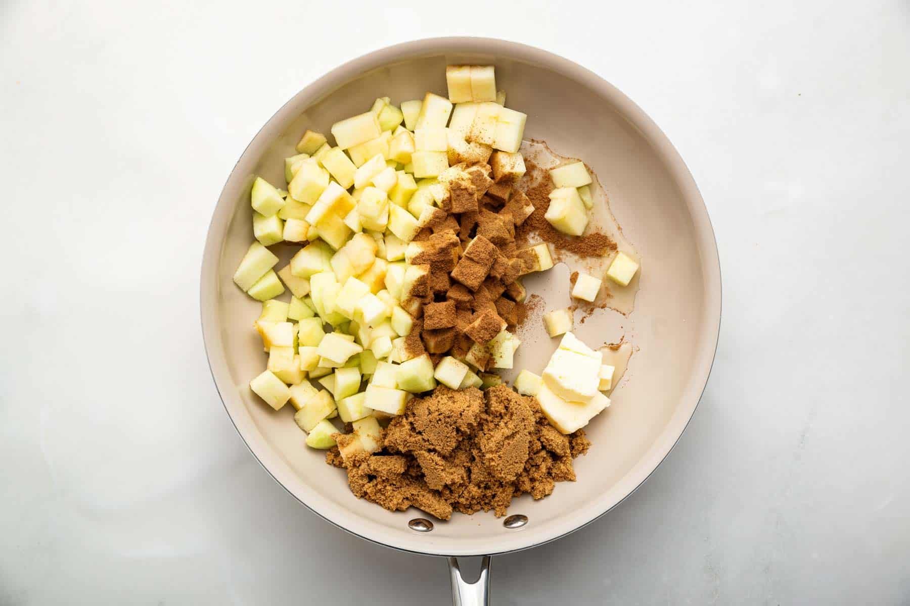 Saute pan with diced fruit, brown sugar, cinnamon and butter in it.