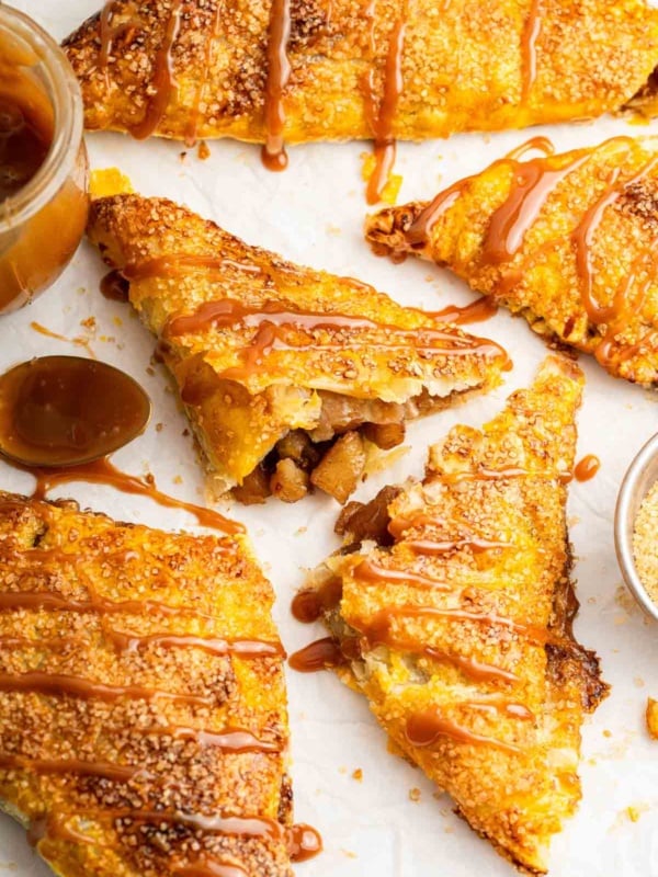 Triangle apple turnovers made with puff pastry and drizzled with caramel.
