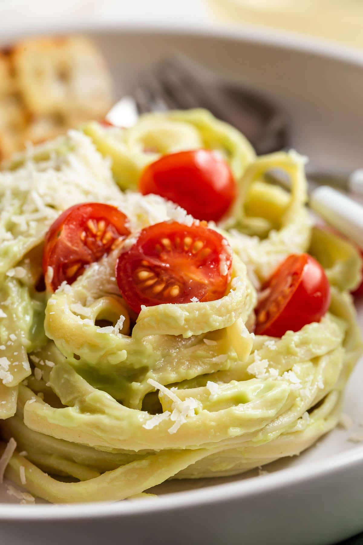 Avocado sauce on noodles with cherry tomatoes.
