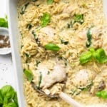 Baked Chicken Orzo with spinach and creamy cheese garnished with basil.