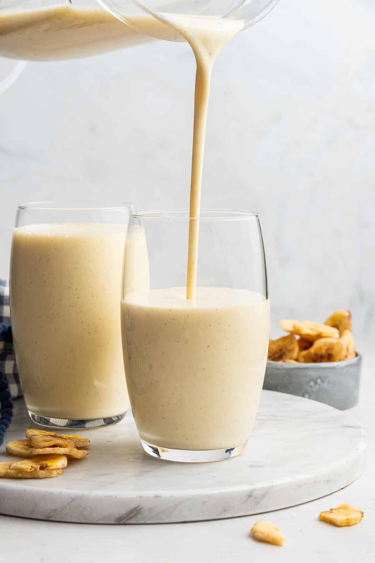 Thick yellow liquid being poured into two glasses.