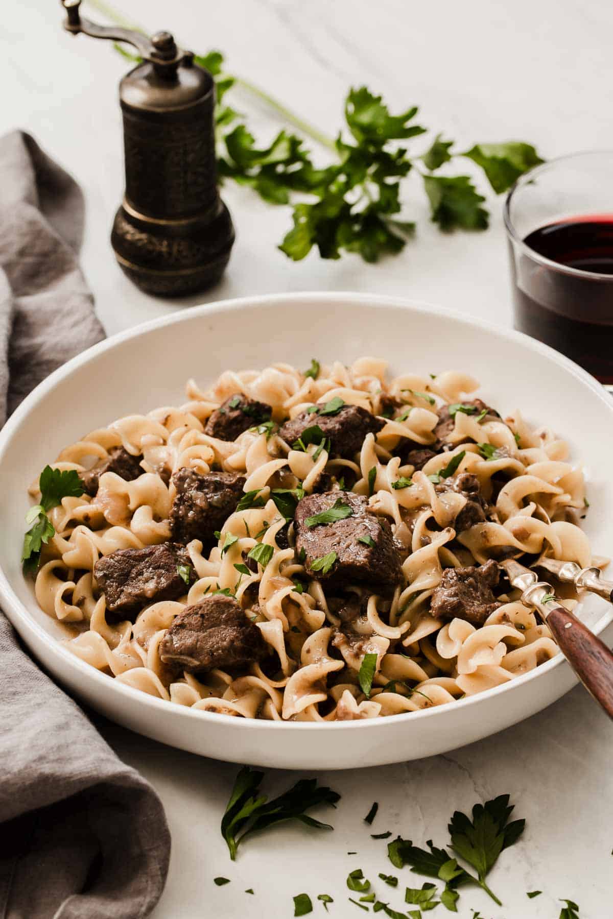 White bowl of beef and egg noodles, ready to serve.