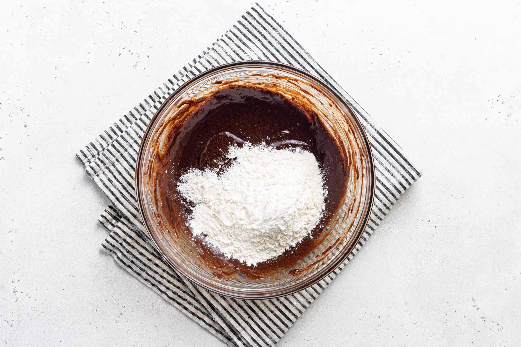 Dry ingredients going into chocolate cupcake batter.