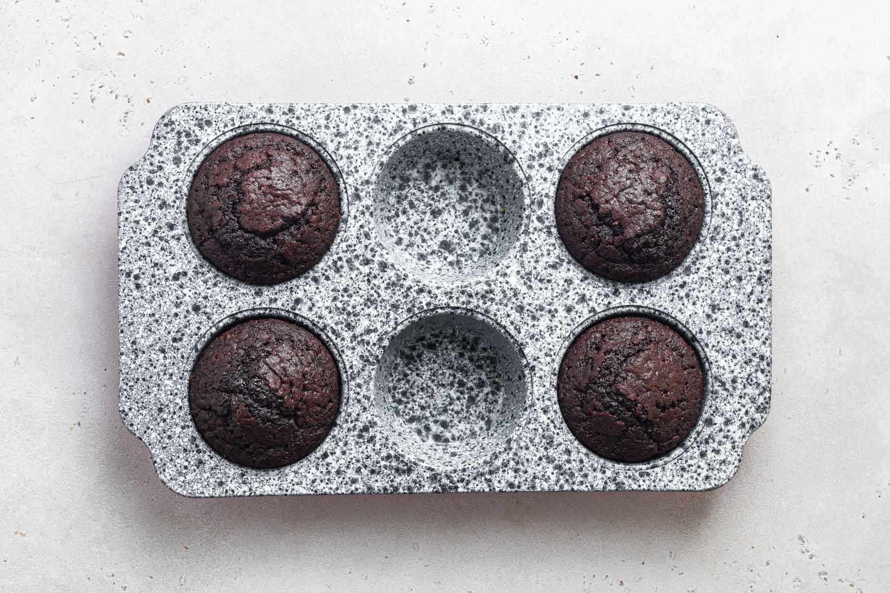 Freshly baked chocolate cupcakes in pan.