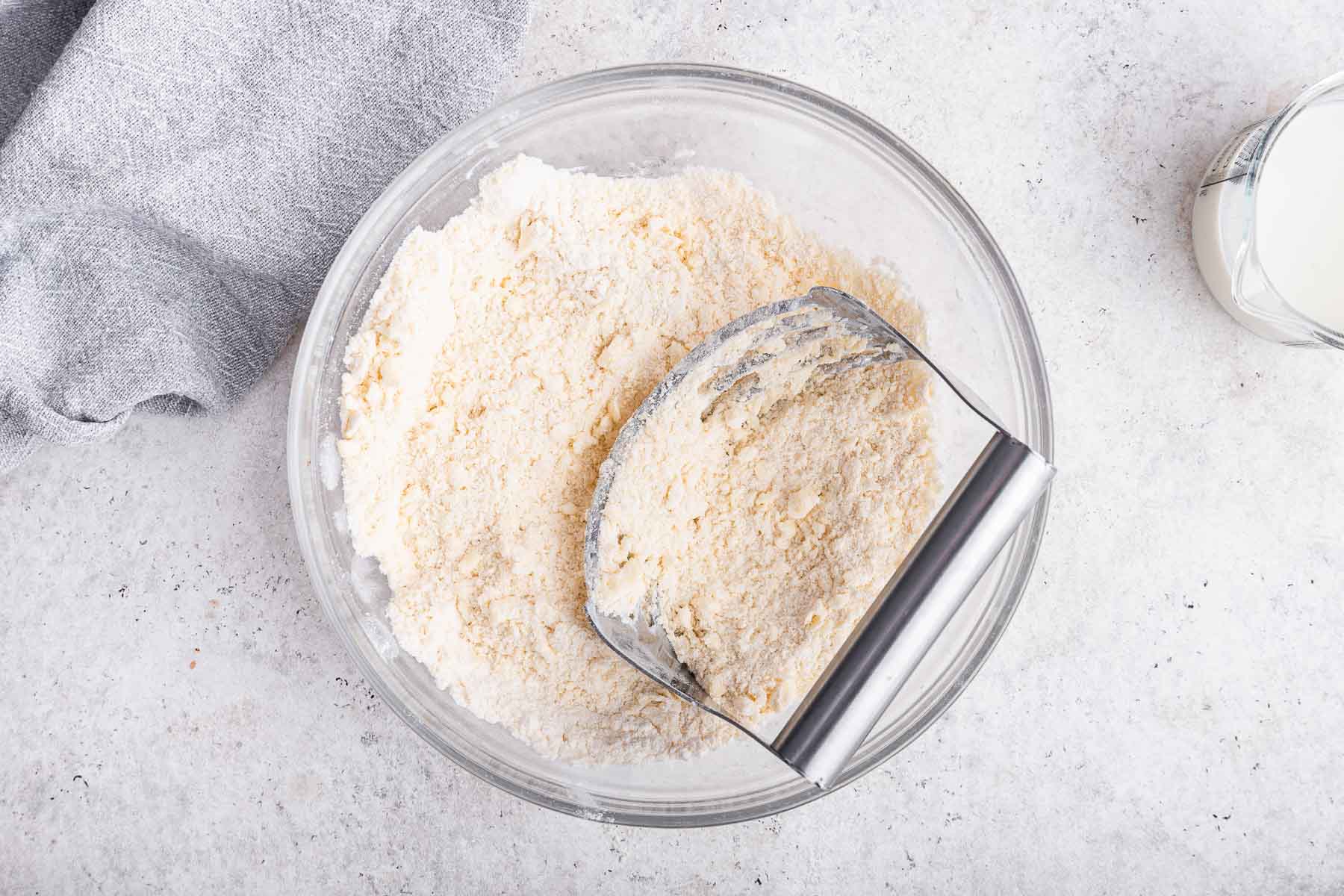 Using a pastry blender to work butter into flour.