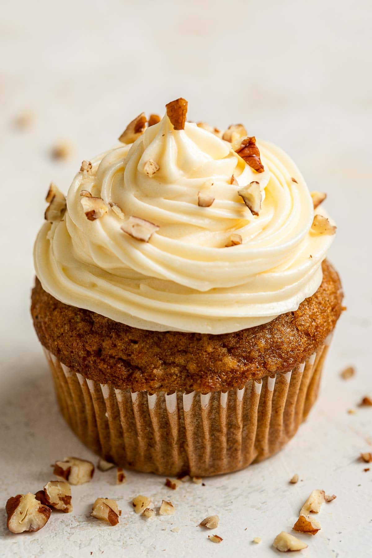 Single carrot cake, decorated with chopped pecans, up close.