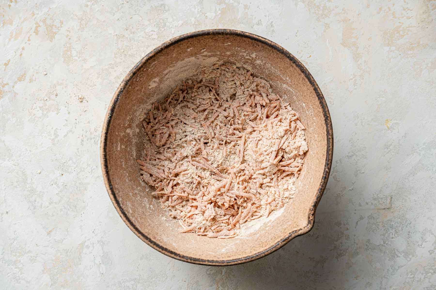 Grated carrots tossed in dry ingredients.