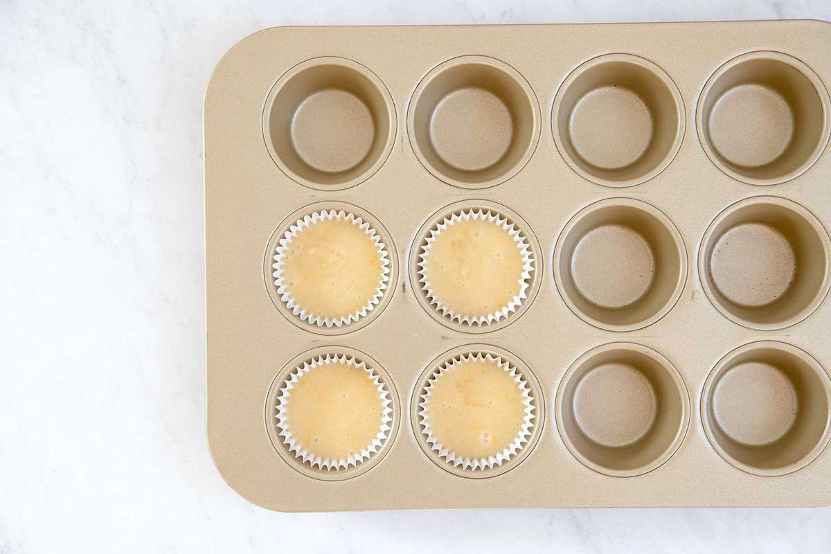 Batter for four cupcakes in a muffin pan.