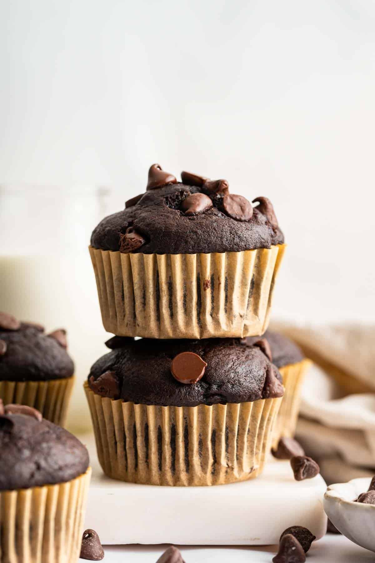 chocolate-banana-muffins Two chocolate banana muffins stacked on top of each other in brown wrappers.
