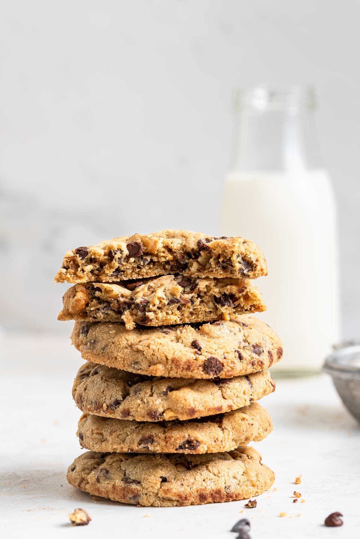 Stacked cookies with milk behind.