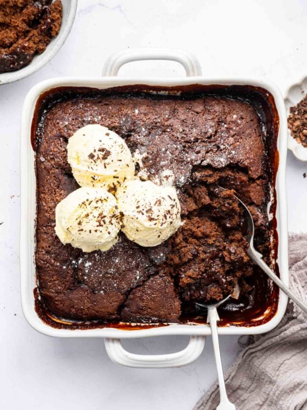 Vertical image of melted chocolate cobbler with scoops of ice cream.