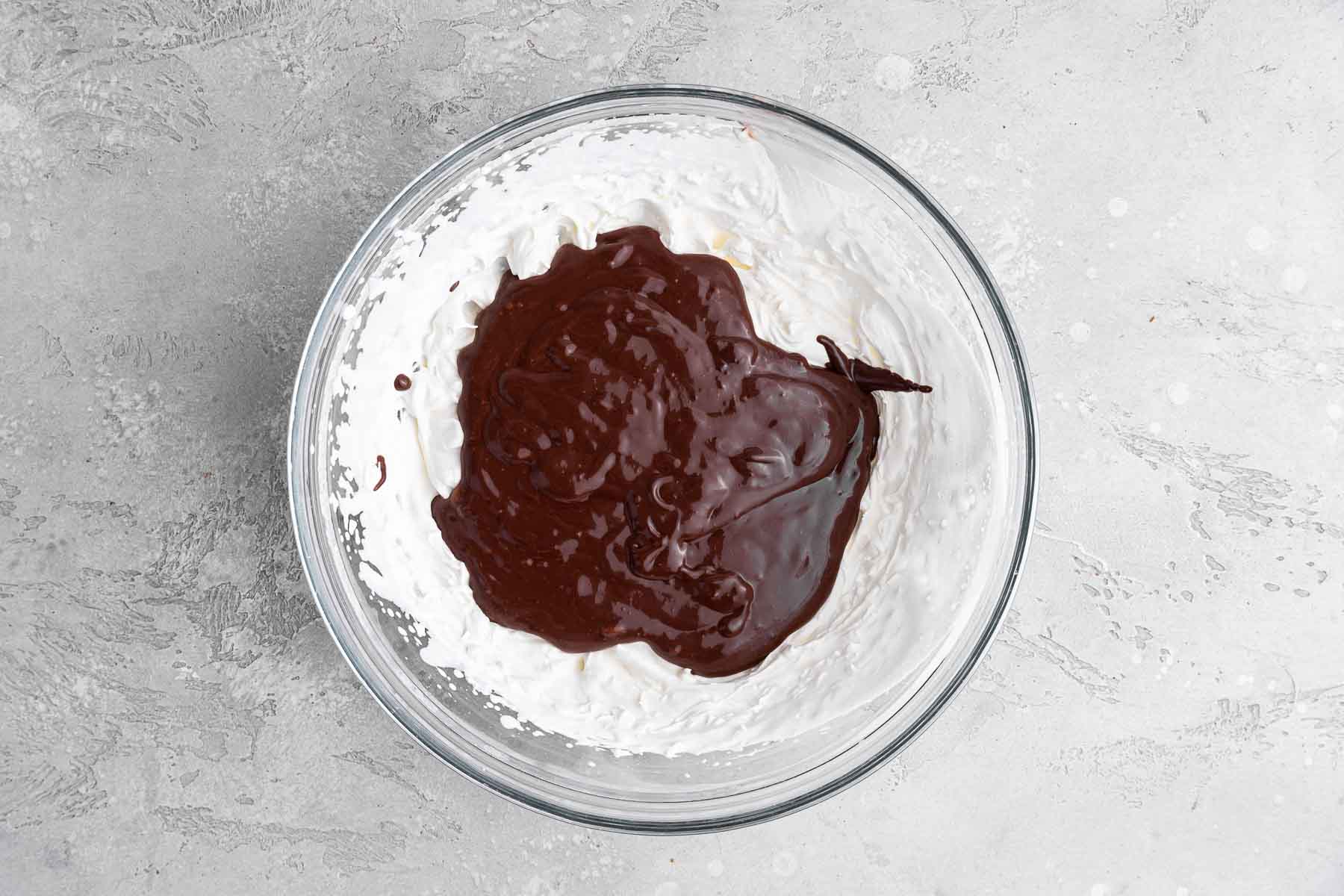 White whipped cream with dark brown liquid on top.