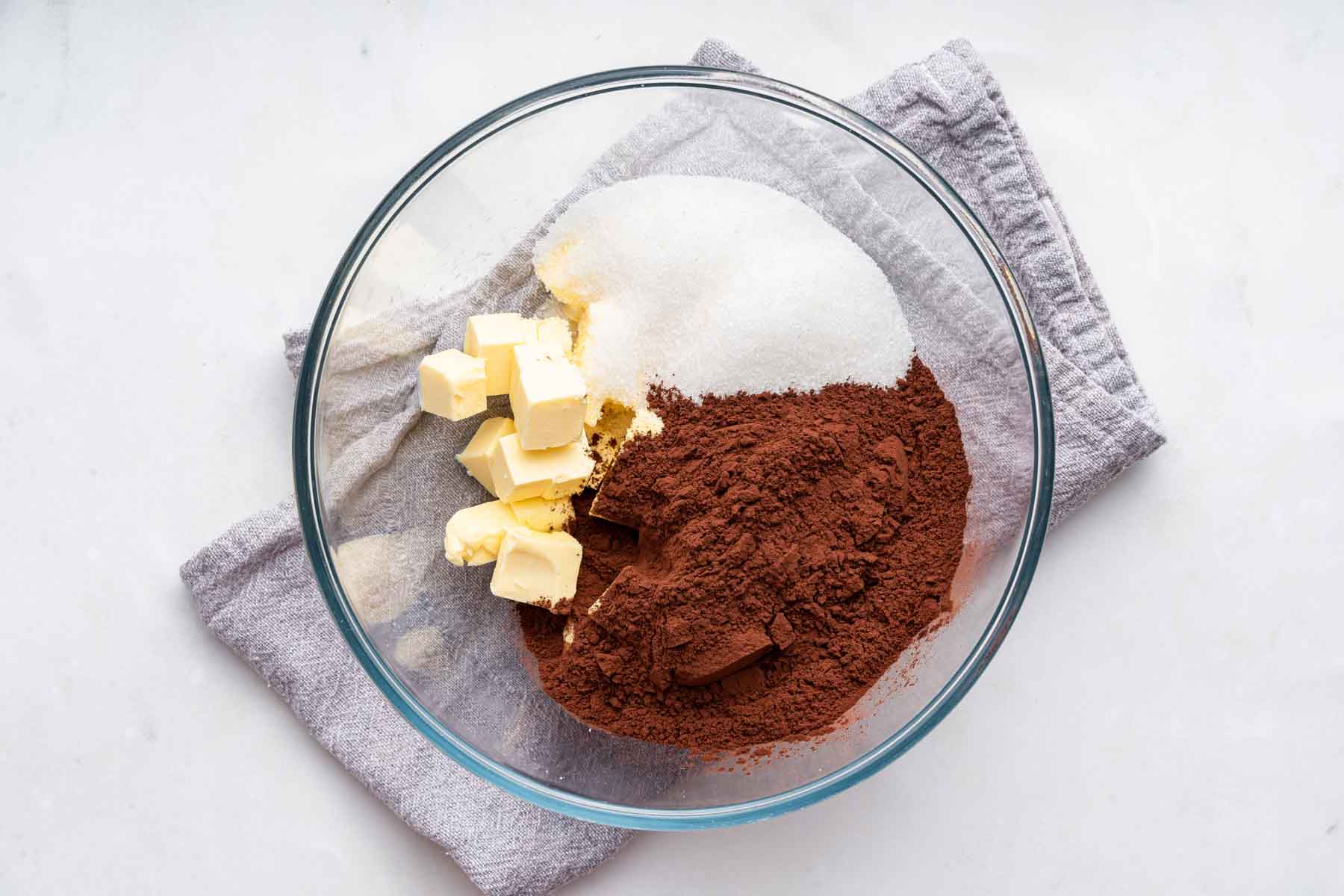 Bowl with butter, cocoa powder and sugar in it.