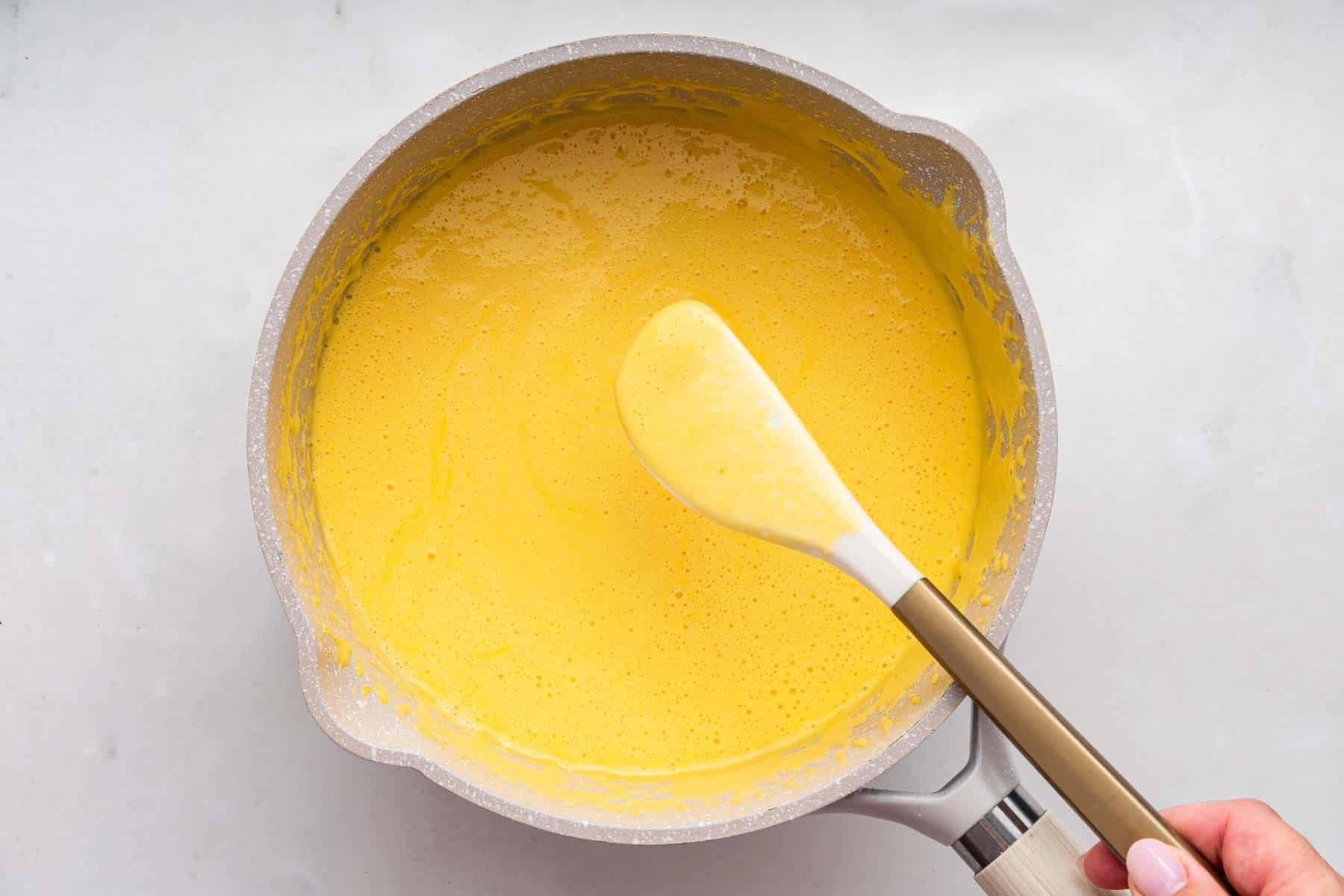 Cooking liquid batter in to with white spatula.