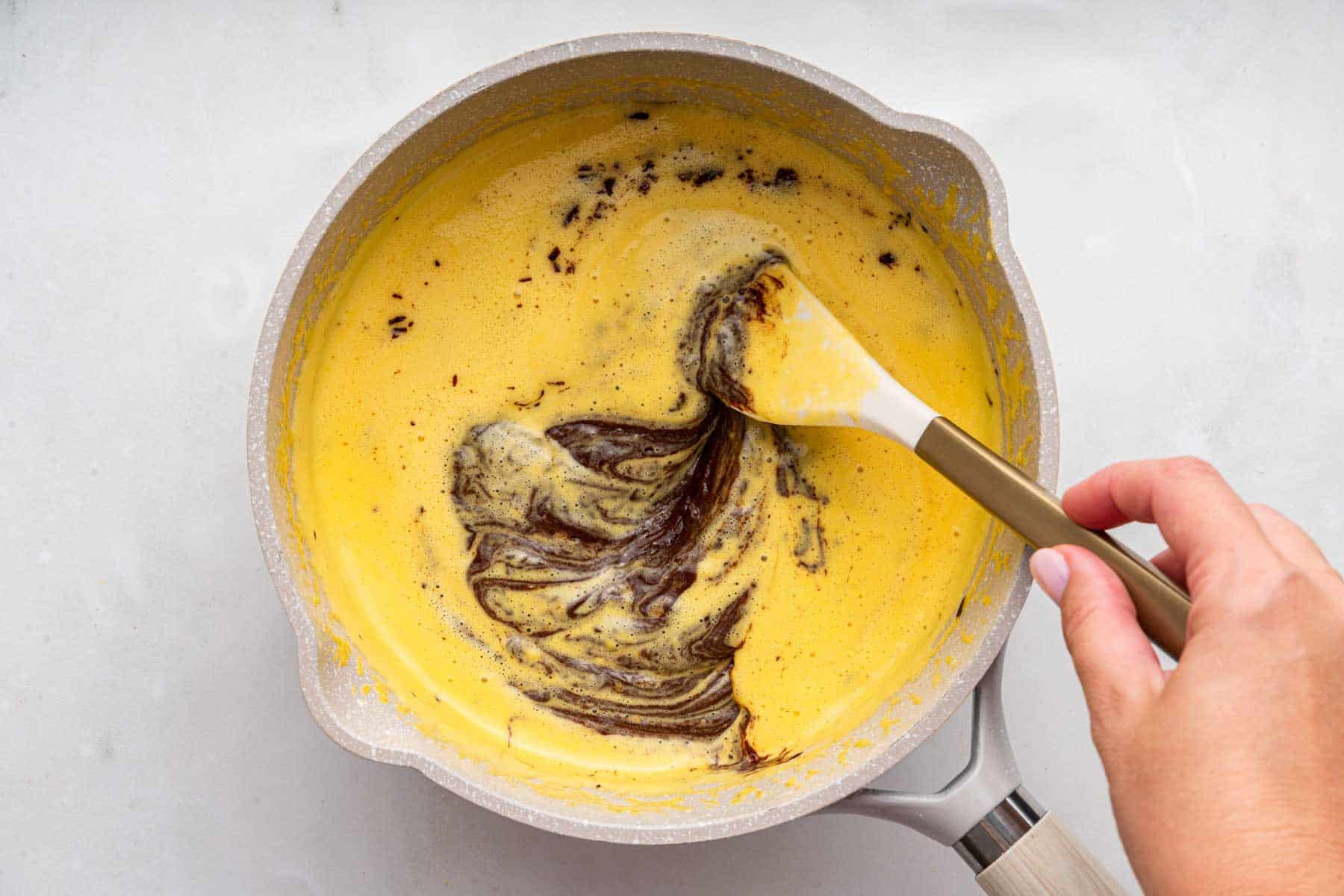 Yellow batter with chocolate stirred in.