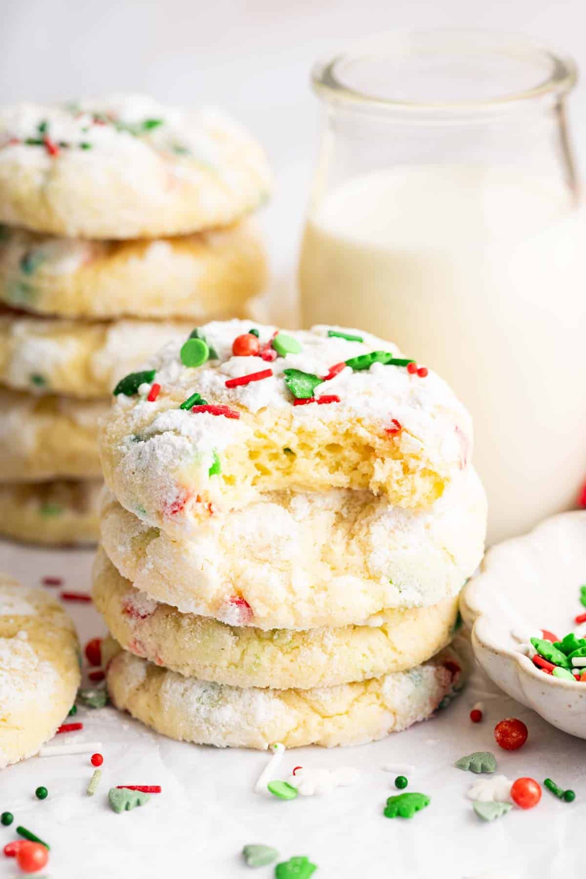 Stack of christmas ooey gooey butter cookies with bite missing on top one.