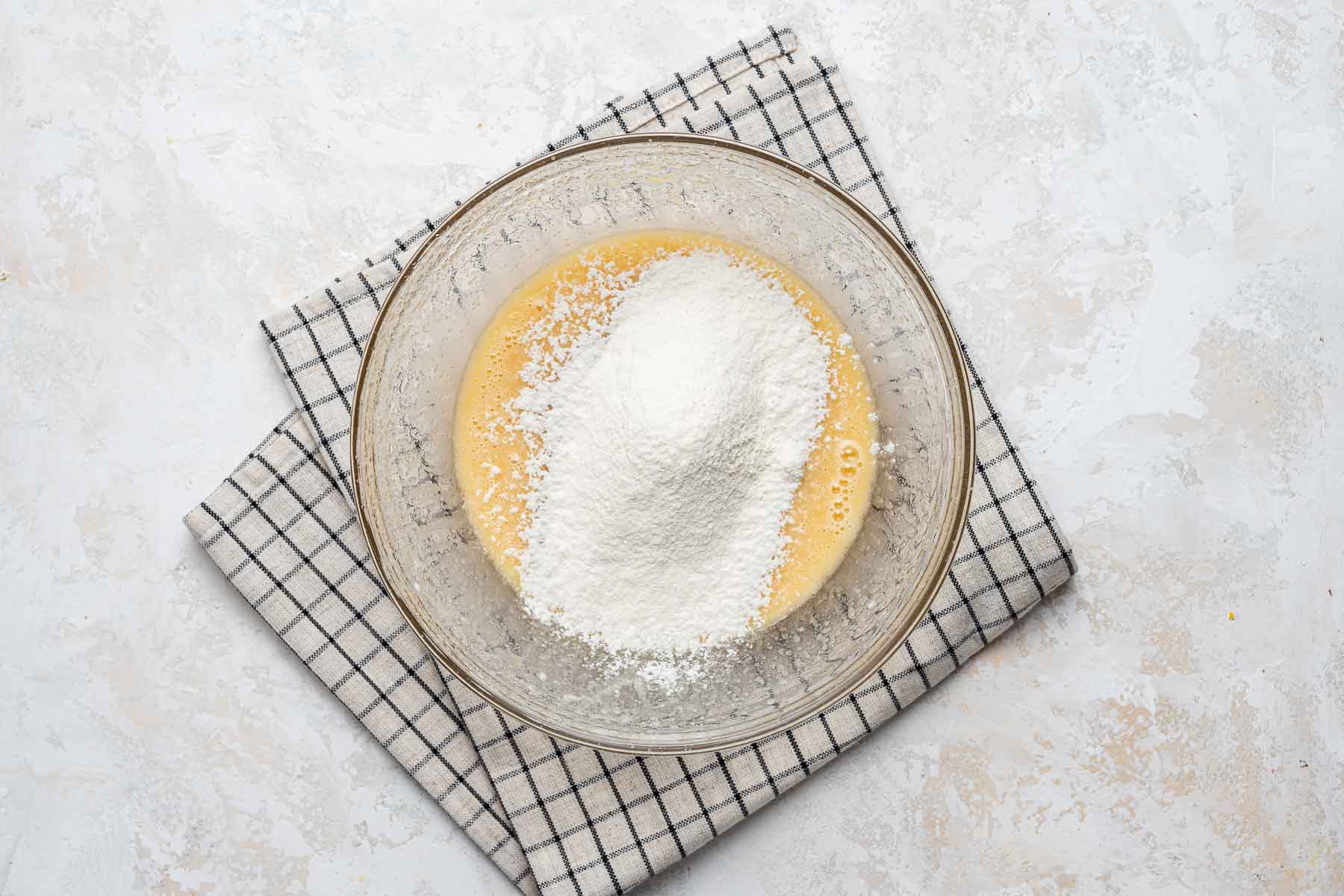 Flour over cupcake batter in bowl.