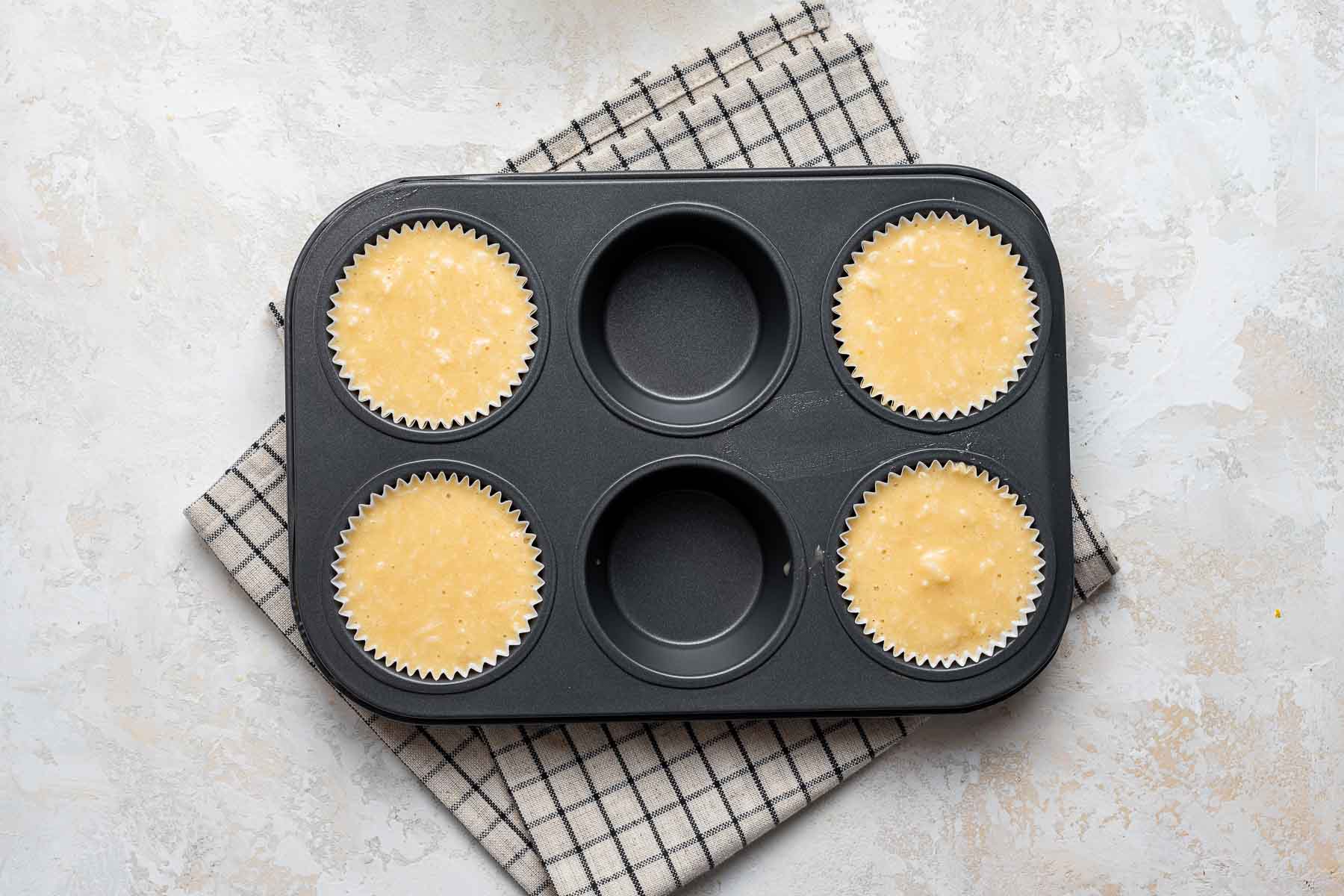 Raw cupcake batter in muffin pan.