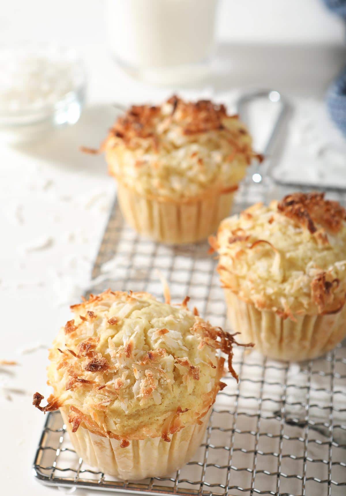 Coconut muffins cooling on wire rack.