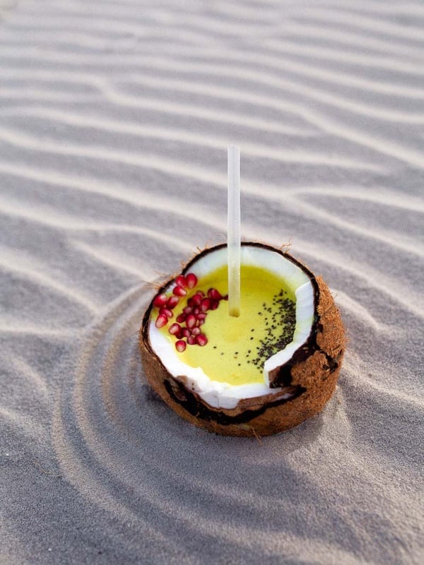 Golden milk recipe for turmeric smoothie in a fresh coconut.