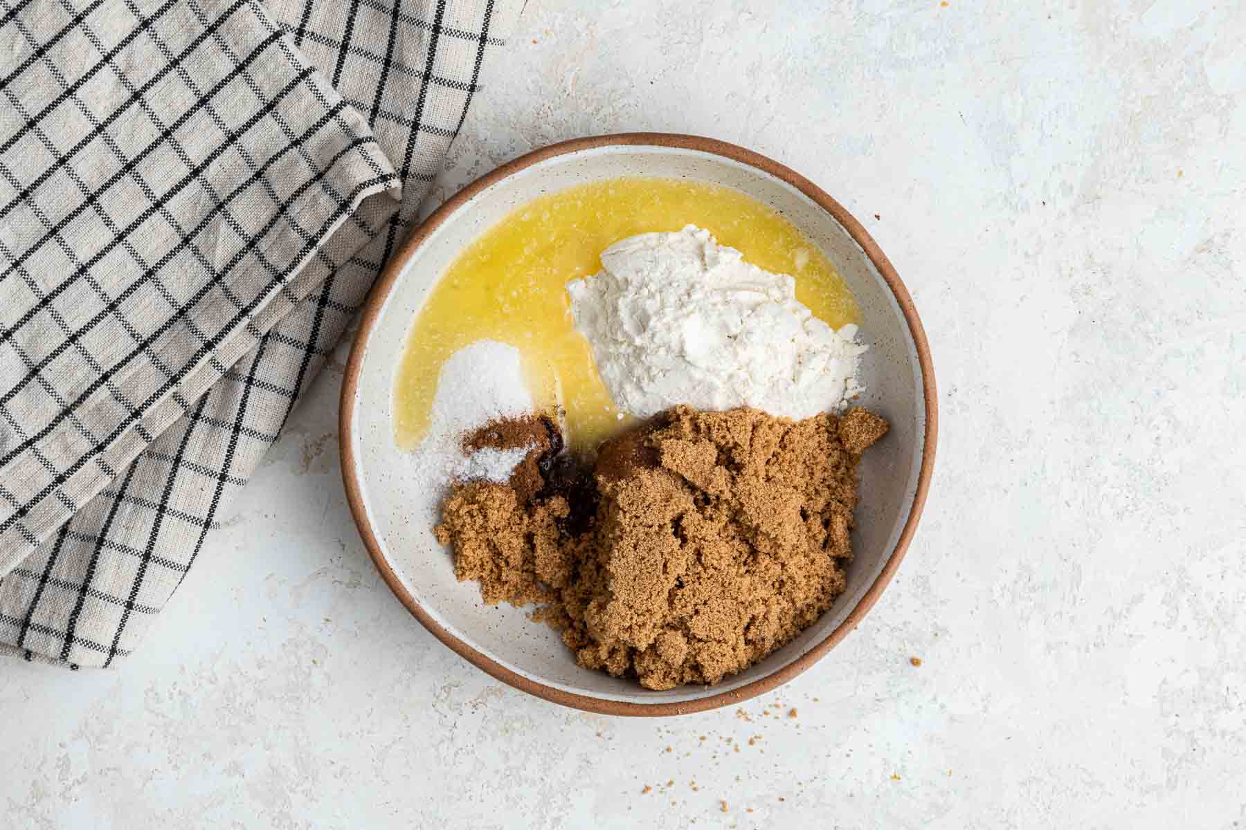 Small rustic bowl with melted butter, brown sugar and flour.