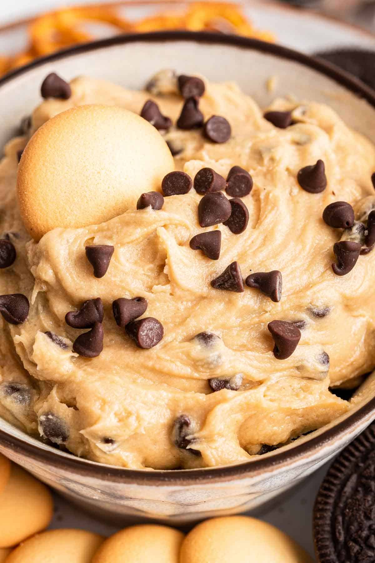 Macro shot of cookie dough dip in bowl with Nilla wafter on top.