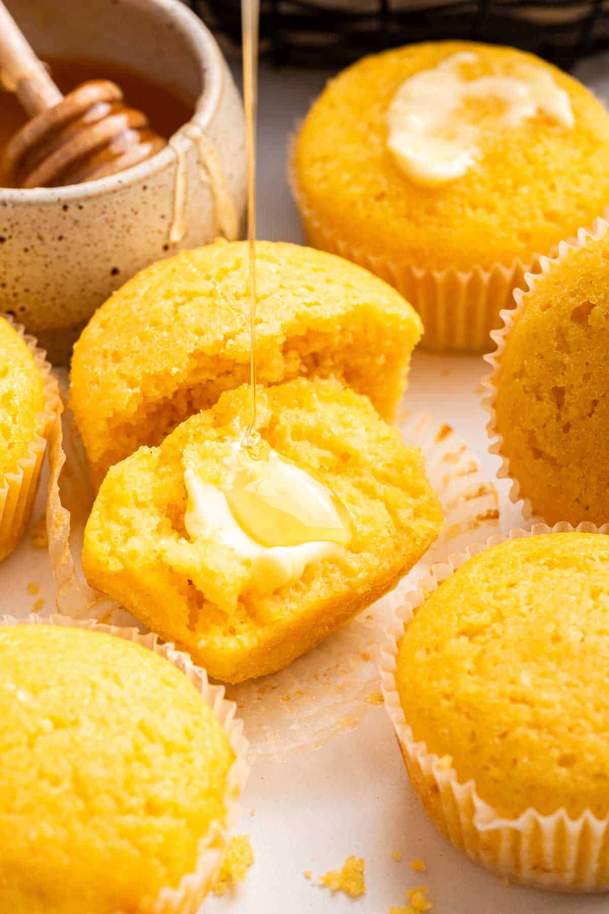 Cornbread muffin cut in half with butter melting on top.