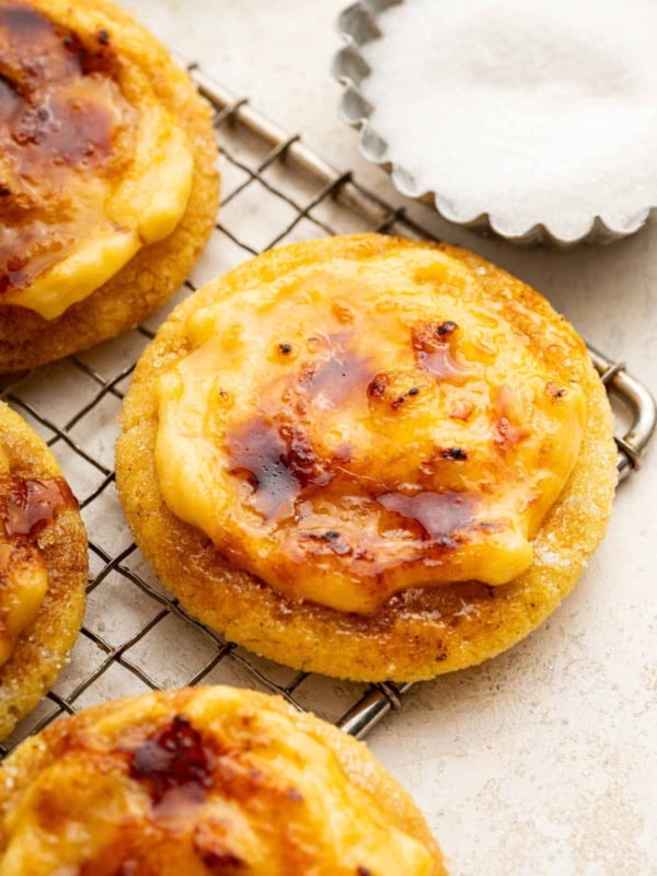 Creme brulee cookies with brown crispy topping on a wire rack.