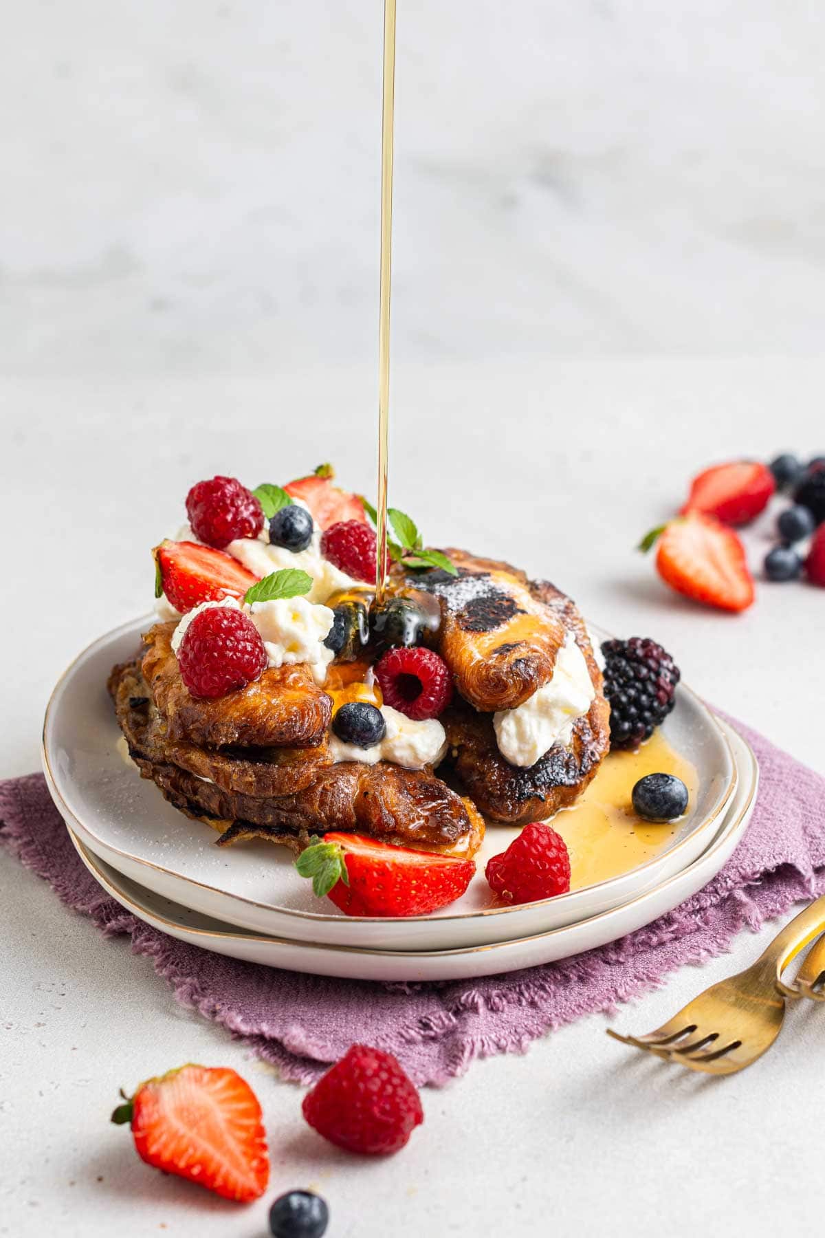 French toast being drizzled with maple syrup.