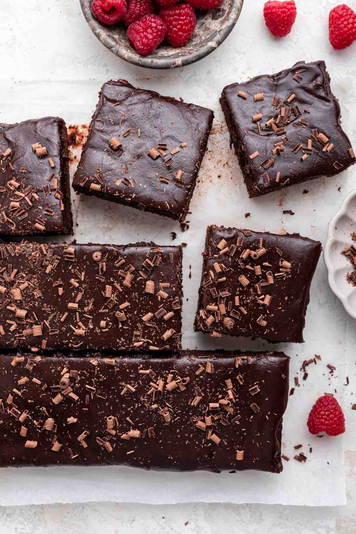 Dr Pepper Cake Vertical image of Dr Pepper cake cut into squares with chocolate shavings on top.