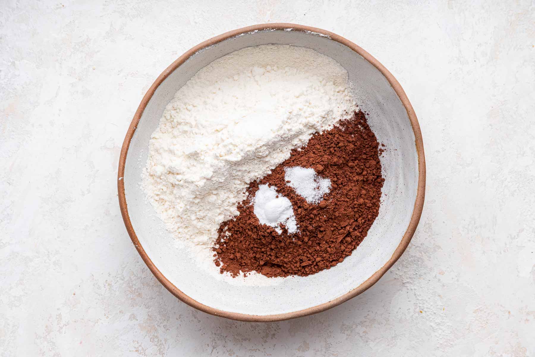 Plate with flour, cocoa and leaveners about to be whisked.