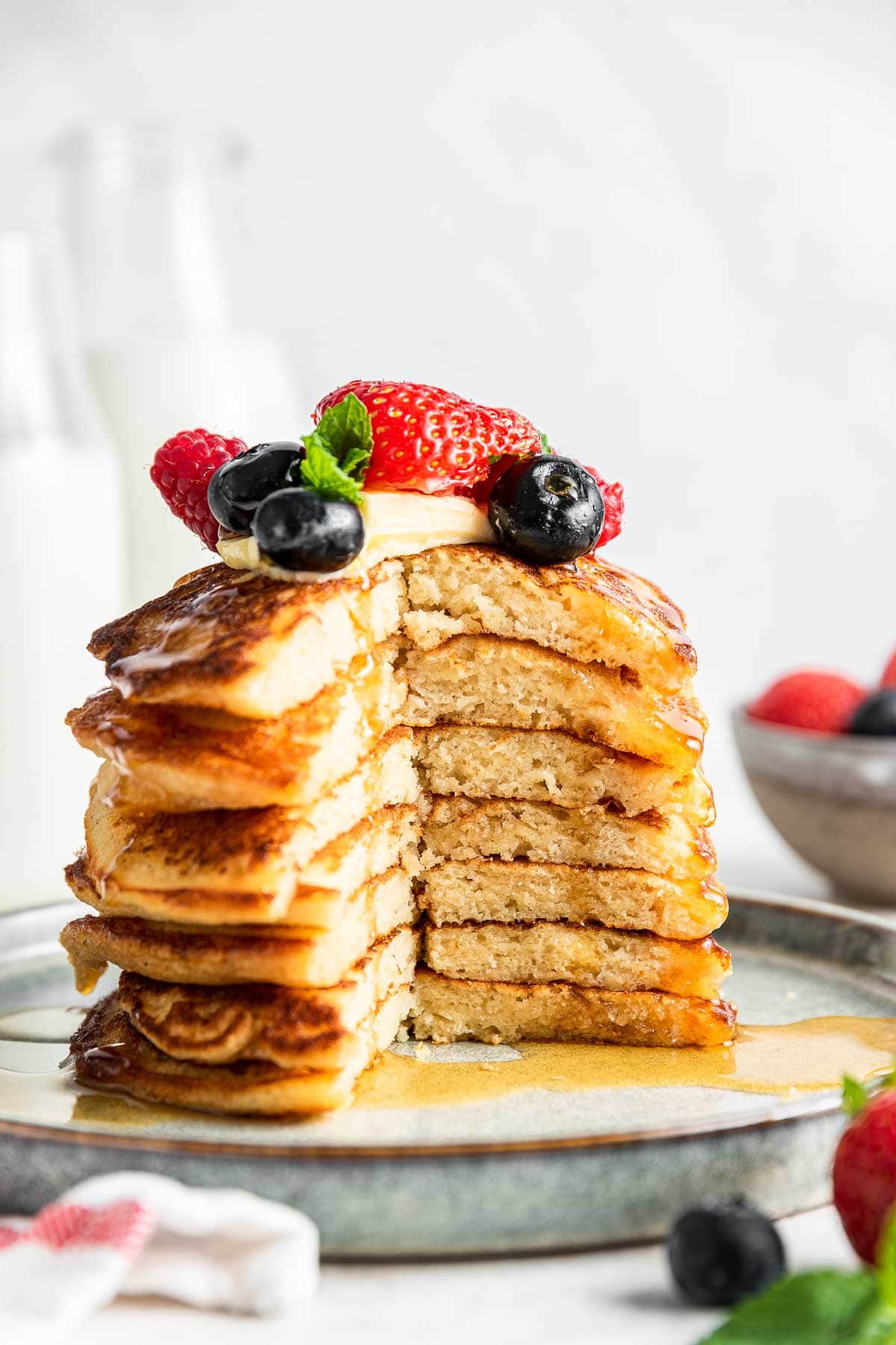 Stack of pancakes with giant bite missing and berries on top.