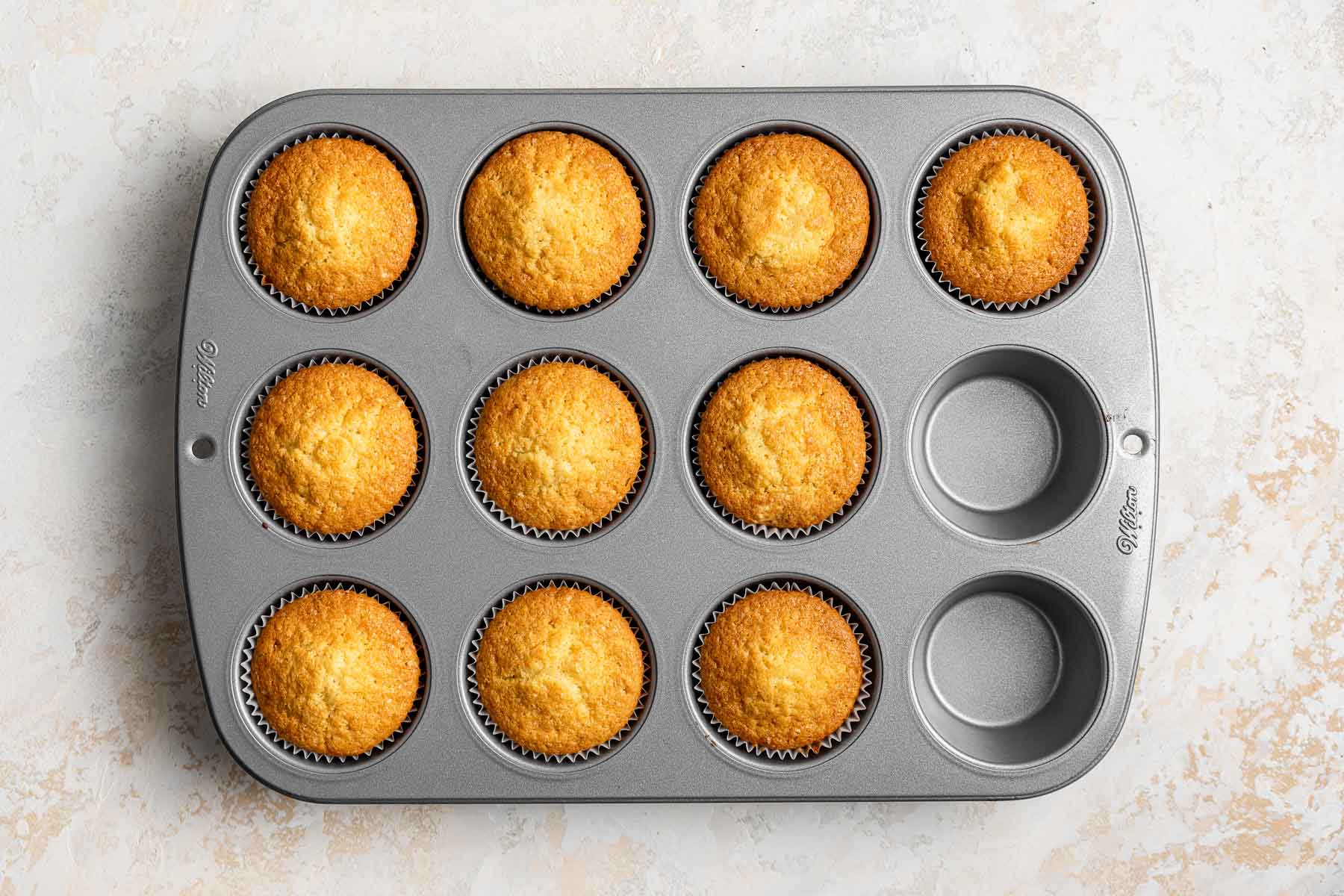 Freshly baked cupcakes still in pan.
