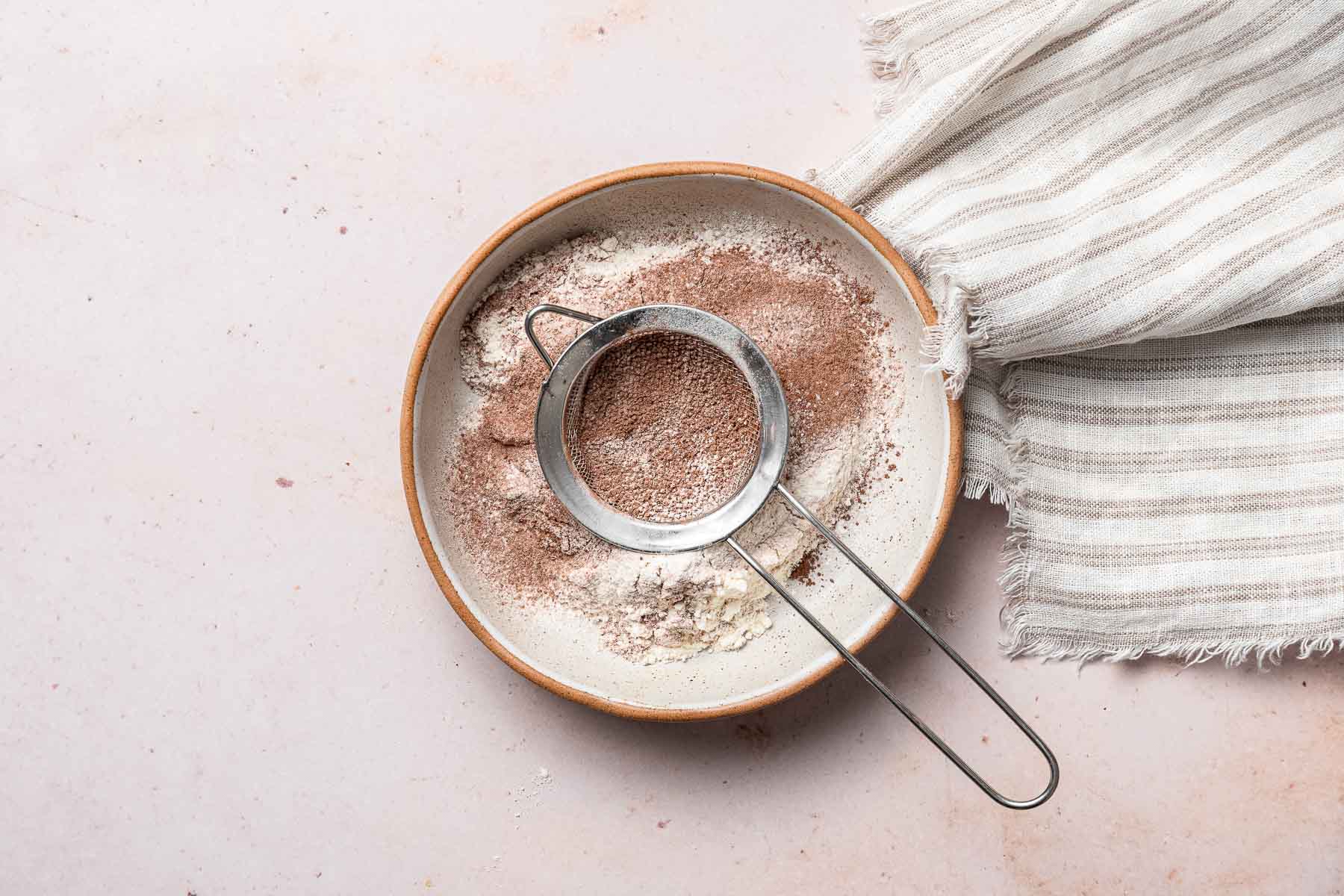 Sifting flour and cocoa powder into small bowl.