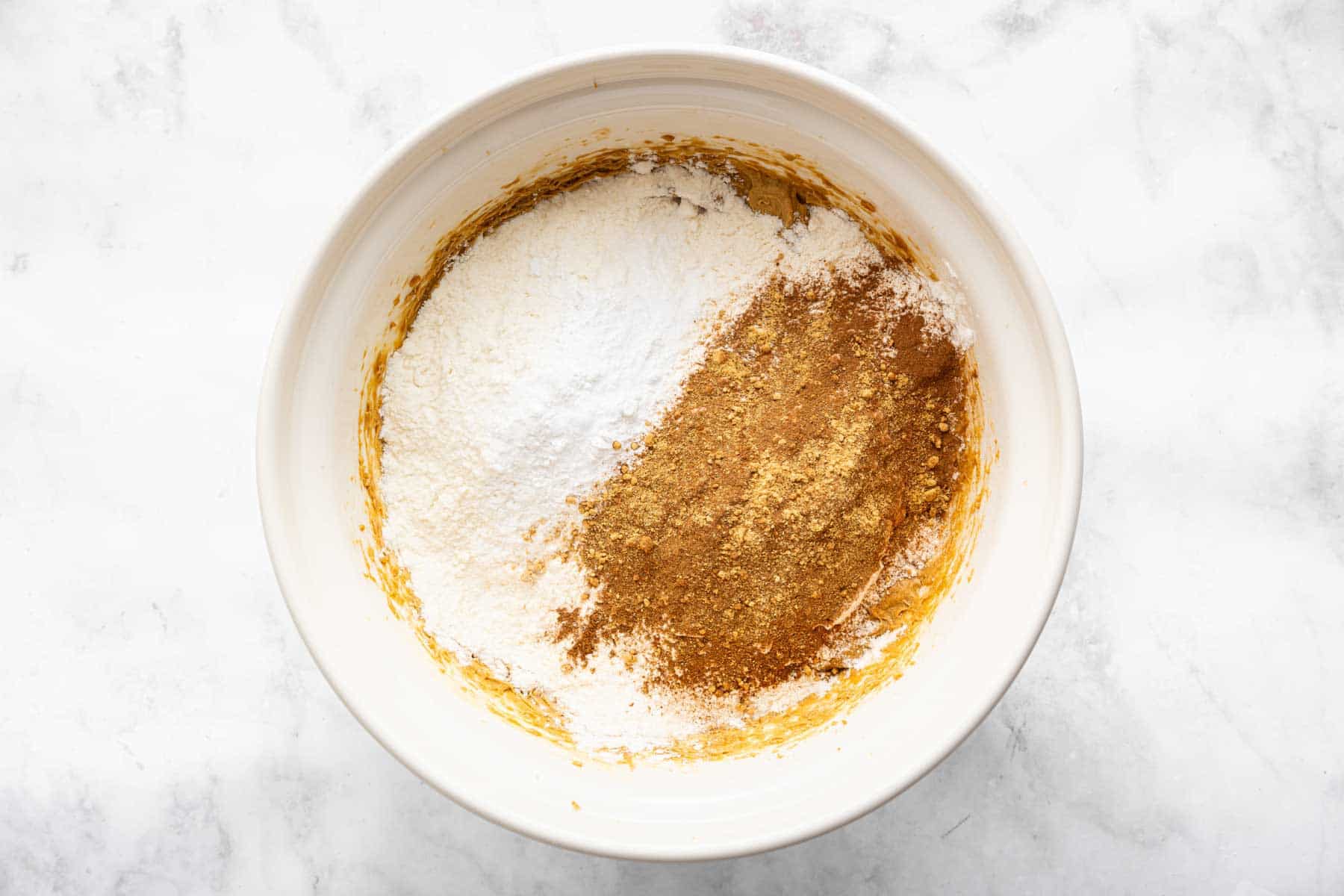 White flour sprinkled to one side of light brown batter.