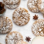 Vertical image of cracked gingerbread cookies dusted with powdered sugar.