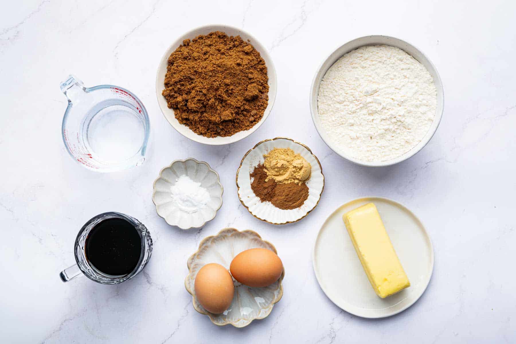 Bowl of molasses, brown sugar, four and spices on kitchen counter.