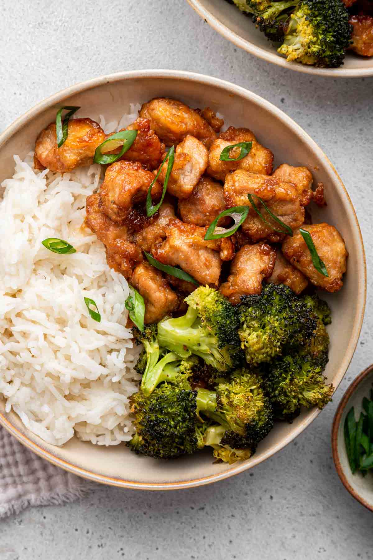 Overhead shot of honey garlic pork in bowl with broccoli and rice.