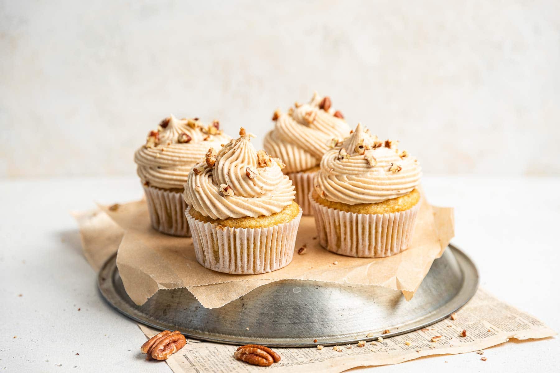 Four frosted cupcakes on an upside down pie plate.