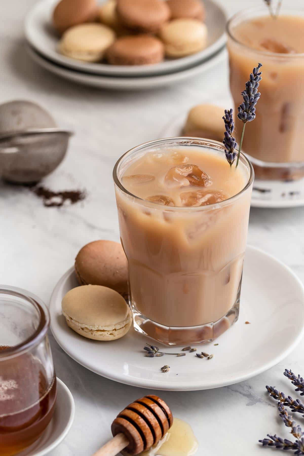 Iced London fog tea with lavender and milk on white plate with cookies.