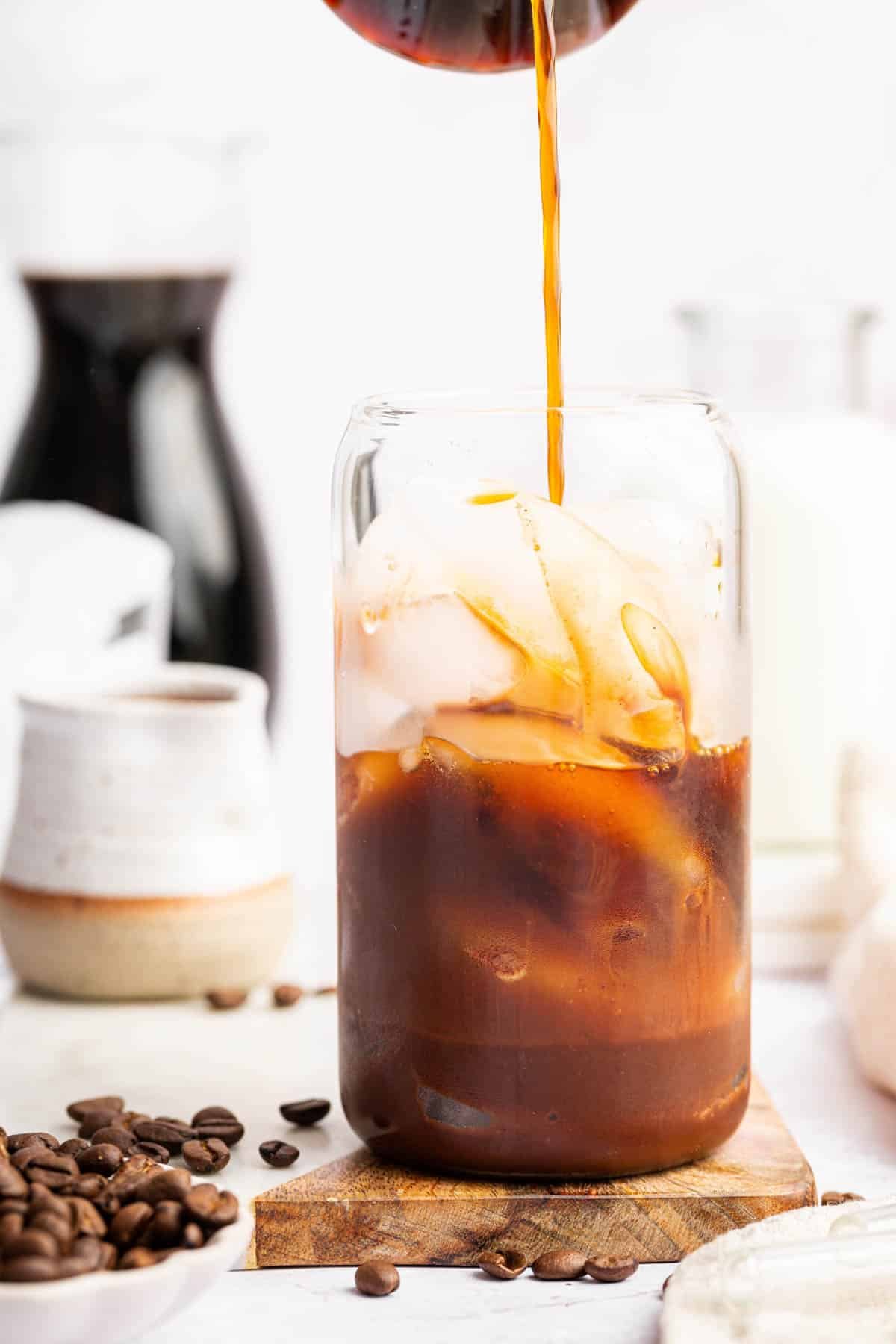 Pouring coffee in glass of ice.