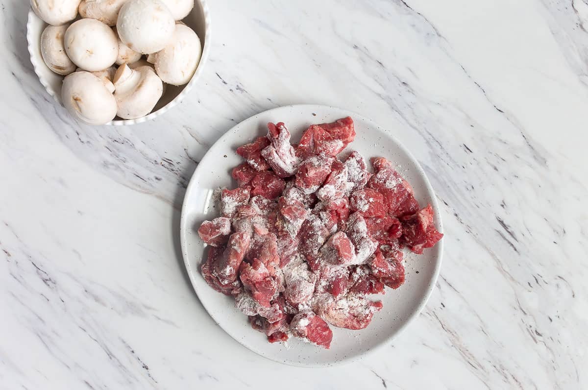 Pieces of beef coated in flour on a plate.