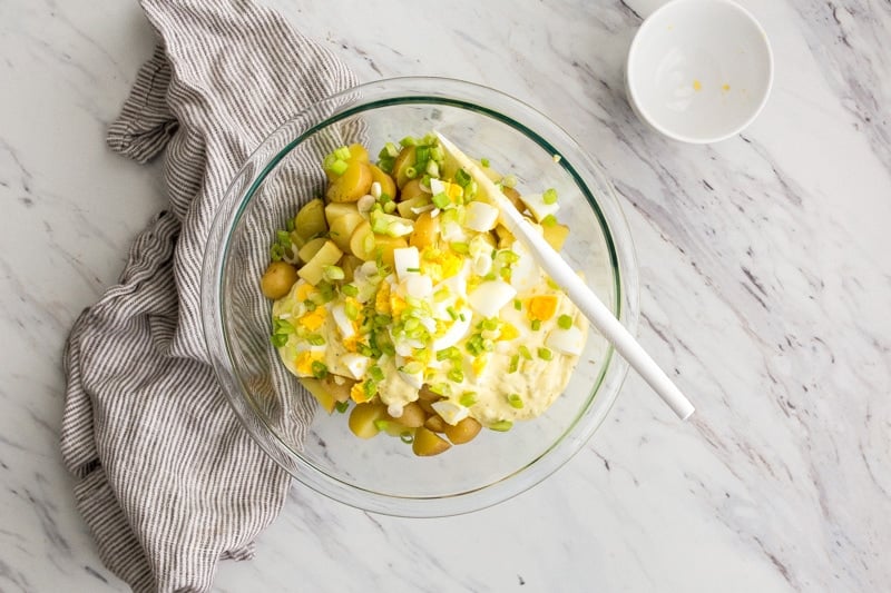 Clear glass bowl with grilling side dish and white spatula.